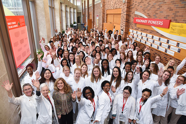a group of students in white coats