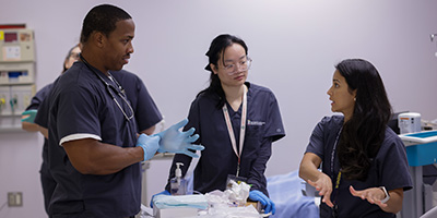 Three student nurses talk in the simulation lab