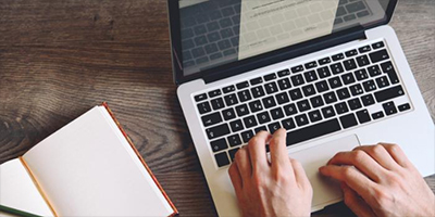 hands typing on a laptop