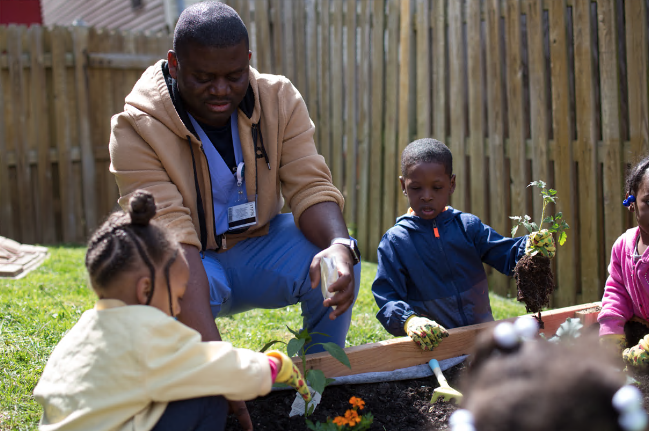 a nursing student working in a community garden with young children