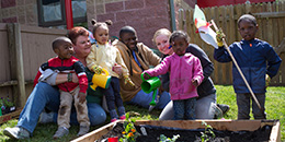 Faculty help children water plants