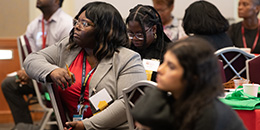 A crowd of people listen to a presentation