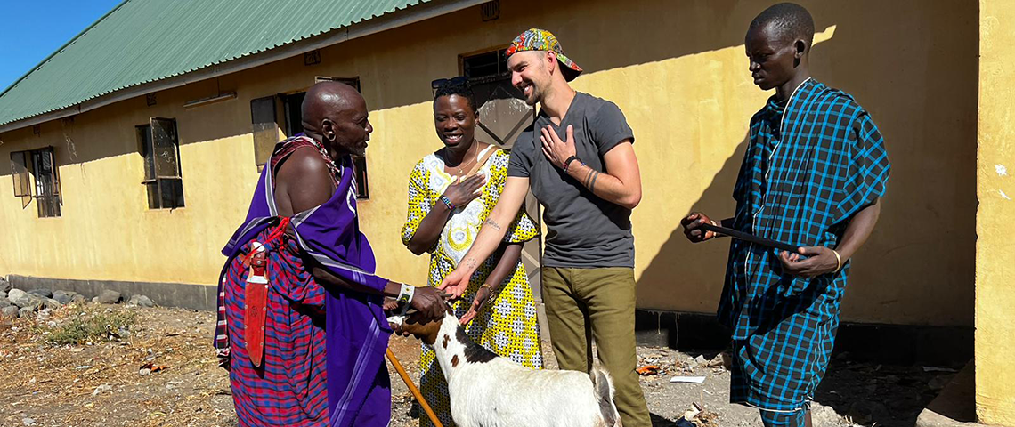 Nwogwugwu (center, left) and Snyder (center, right) present a goat to a Maasai chief as a token of gratitude for his support of EHCO hospital.
