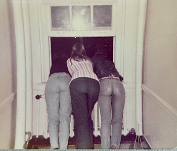 Girls hanging out a window in Parsons Hall