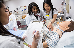 students practicing on a manikin in the simulation lab