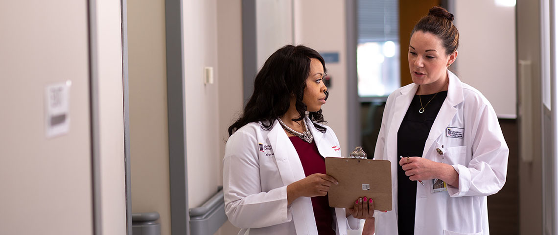 a student talks with their preceptor in a hallway