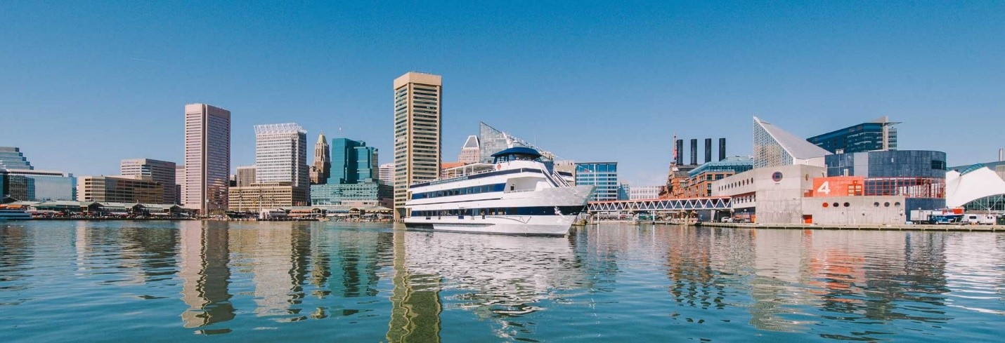 The Spirit of Baltimore boat in the Inner Harbor with the Baltimore skyline behind it.