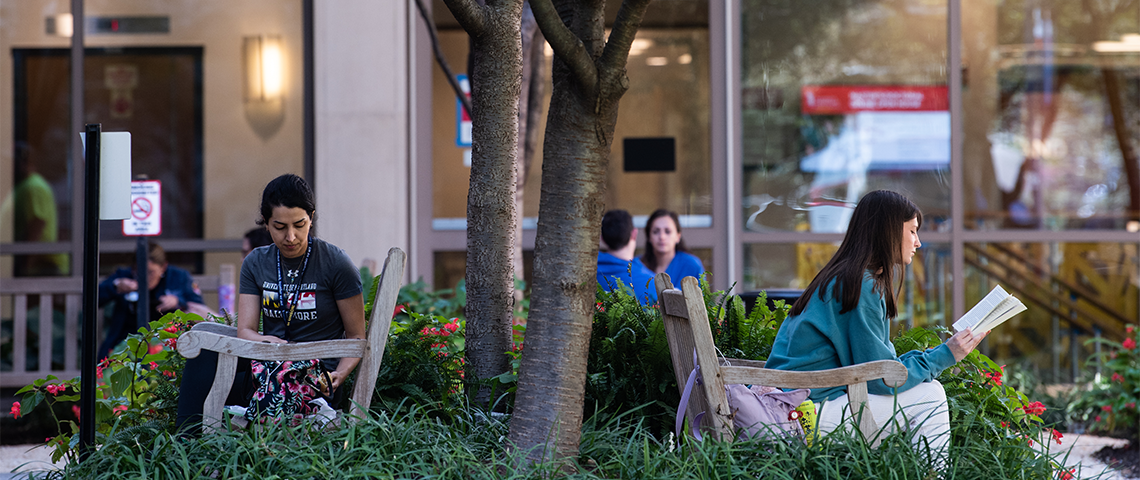 Two students sit outside UMSON reading