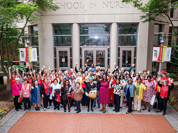 Alumni Reunion attendees waiving to the camera in front of the UMSON building
