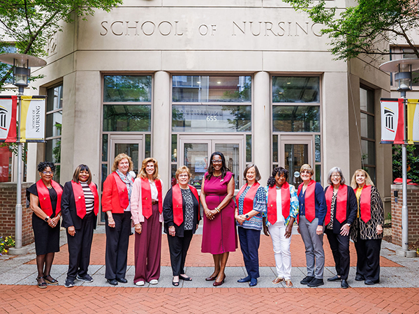 Dean Ogbolu poses with the Heritage Class in front of the UMSON building