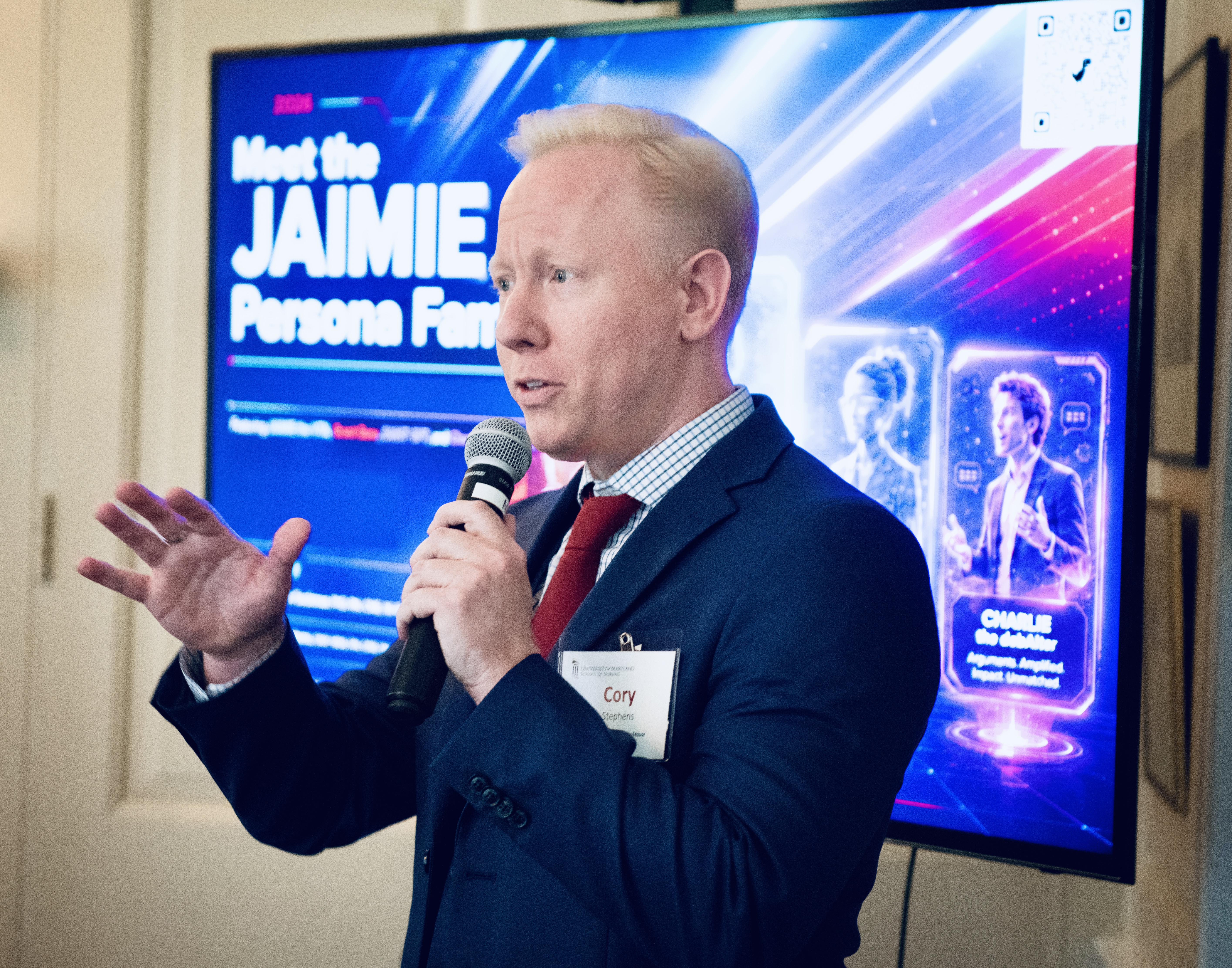 Cory Stephens standing before a projection screen as he discusses JAIMIE, a virtual teaching assistant.