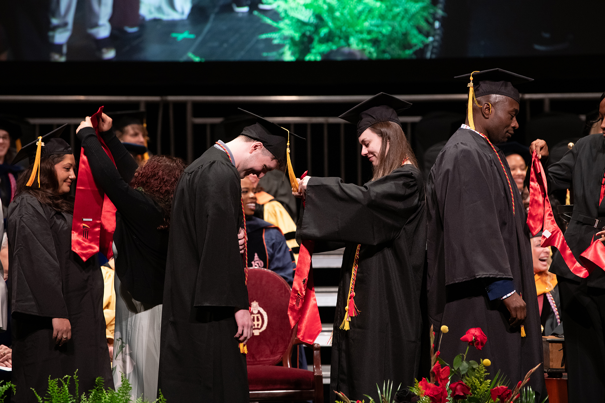 Two siblings pinning at grad ceremony