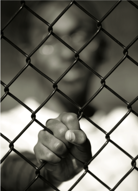 a man behind a chain-link fence